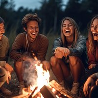 Joyous group of millennials laughing and bonding around a campfi